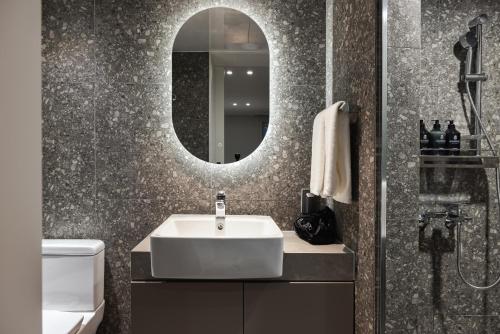 bagno con lavandino e specchio di Kensington Resort Jeju Jungmun a Seogwipo