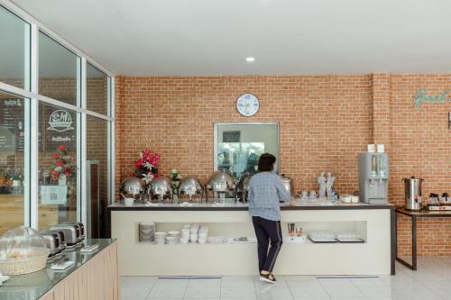 a person standing at a counter in a kitchen at Ioon Resort ไออุ่นรีสอร์ท in Sara Buri