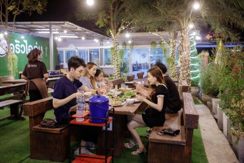 a group of people sitting at a table in a restaurant at Ioon Resort ไออุ่นรีสอร์ท in Sara Buri