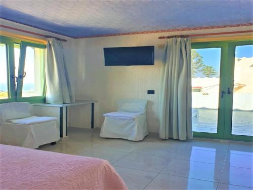 a bedroom with a bed and a table and windows at Executive Junior Suite in Hersonissos