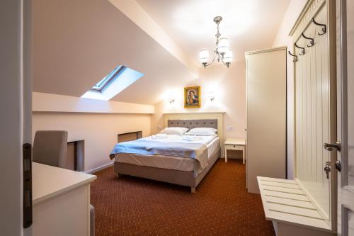 - une chambre avec un lit, un bureau et une fenêtre dans l'établissement Apartament Hotel H, à Orăştie