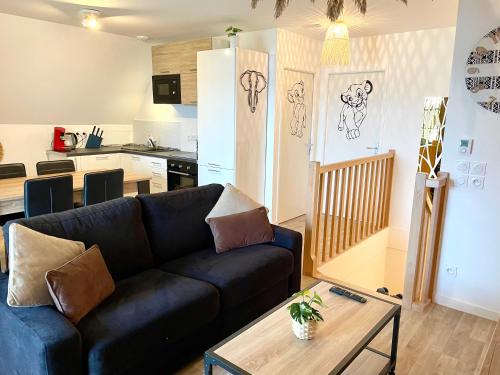 a living room with a couch and a kitchen at Bel appartement « The Lion King » proche Disney in Montévrain