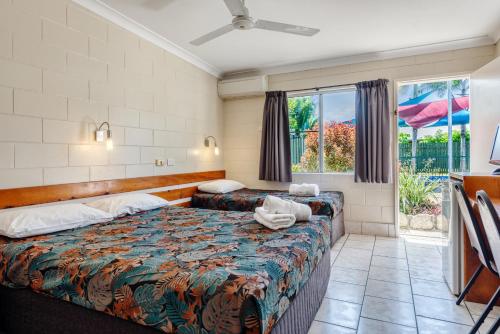 um quarto de hotel com uma cama e uma janela em Demi View Motel em Mossman