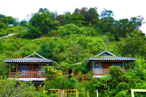 two huts on top of a hill with trees at Kodai Heaven in Kodaikānāl