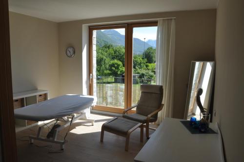 a living room with a table and a chair and a window at Tullio Hotel in Gravedona