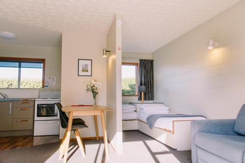 a room with two beds and a table and a couch at Flaxbourne Motels in Ward