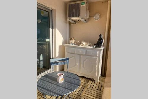 une cuisine avec un évier et une table avec une chaise dans l'établissement Escapade au port, à Hyères