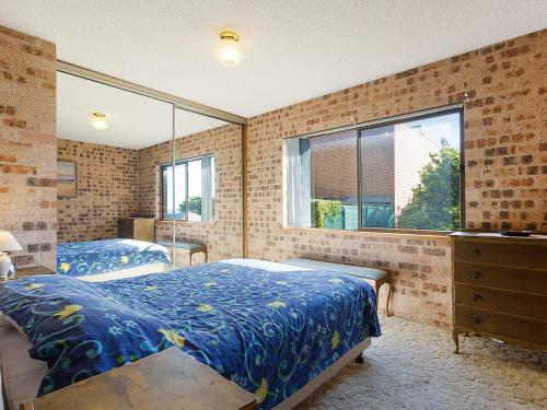 a bedroom with two beds and a window at Pacific Pines Unit 4 in Narooma