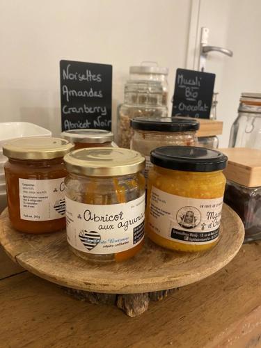 vier potten honing op een houten bord bij Hôtel La Maison des Dunes in Erdeven