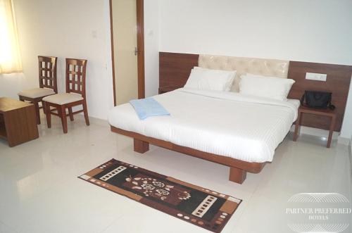 a bedroom with a bed and a table and chairs at PPH Living BSK Deluxe in Bangalore