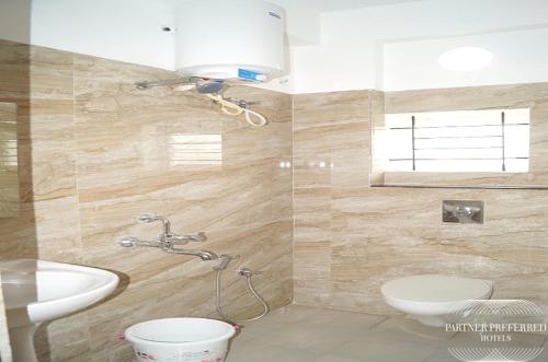 a bathroom with a toilet and a sink at PPH Living BSK Deluxe in Bangalore