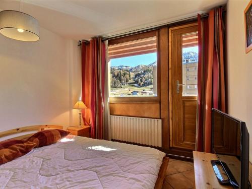 a bedroom with a bed and a large window at Appartement La Plagne, 2 pièces, 5 personnes - FR-1-455-56 in La Plagne