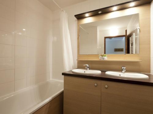 y baño con 2 lavabos, bañera y espejo. en Appartement Brides-les-Bains, 3 pièces, 8 personnes - FR-1-512-1, en Brides-les-Bains