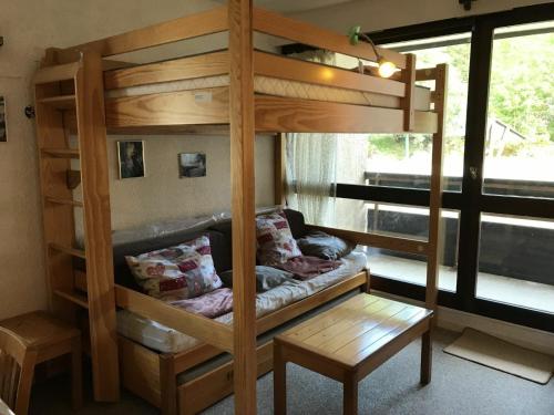 a bunk bed with a couch in a room at Studio Corrençon-en-Vercors, 1 pièce, 4 personnes - FR-1-515-92 in Corrençon-en-Vercors