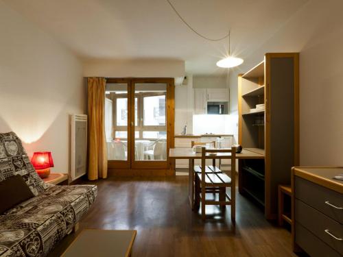 een woonkamer met een bank en een tafel en een keuken bij Studio Brides-les-Bains, 1 pièce, 4 personnes - FR-1-512-14 in Brides-les-Bains