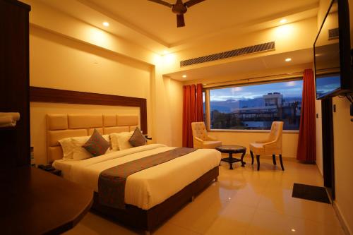 um quarto de hotel com uma cama e uma janela em Hotel Doon's Pride em Dehradun