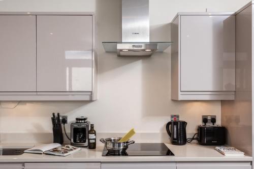 a kitchen with white cabinets and a counter top at Large 2 Bedroom Apartment in Ashford with PARKING in Ashford