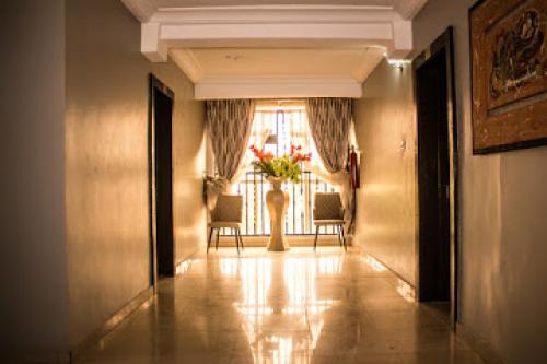 a hallway with a table and chairs and a window at Oragon Hotel -Penthouse in Lagos