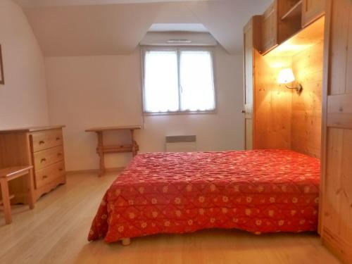 1 dormitorio con cama roja y ventana en Appartement Brides-les-Bains, 2 pièces, 6 personnes - FR-1-512-153, en Brides-les-Bains