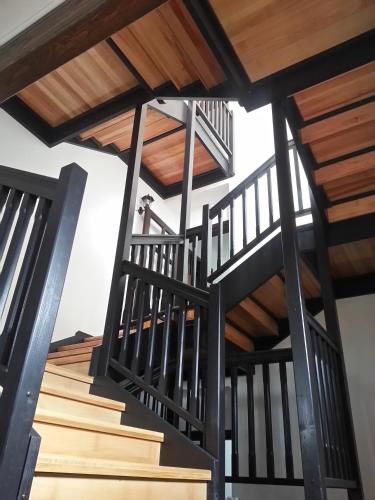 an image of a wooden spiral staircase with wooden railing at Pensiunea Crai Nou in Şirnea