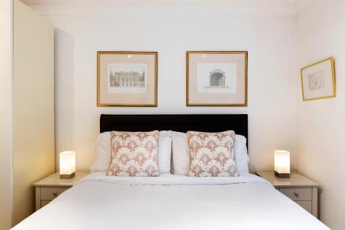 a bedroom with a bed with two lamps on two tables at Spacious 3 bedroom apt in Covent Garden in London