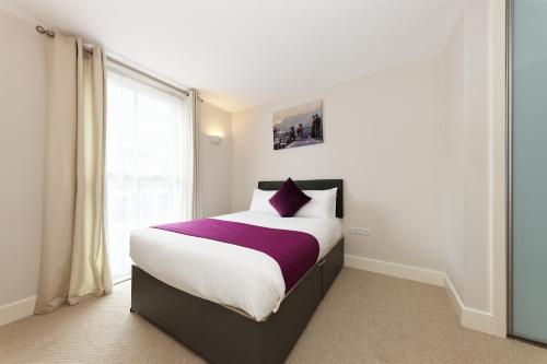 a bedroom with a large bed and a window at Flagstaff Apartment with Secure Parking in Kent