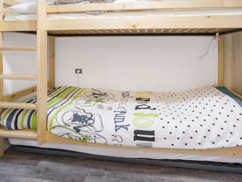 a bedroom with a bunk bed with a comforter at Studio Villard-de-Lans, 1 pièce, 4 personnes - FR-1-515-96 in Villard-de-Lans