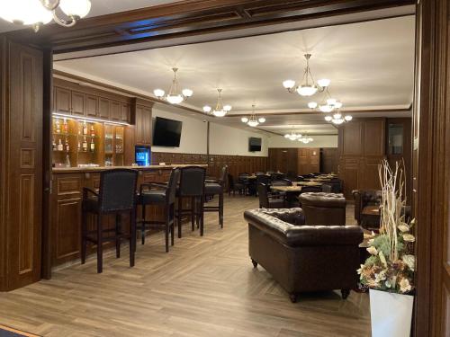 a dining room with a bar and tables and chairs at Parkhotel Brno in Brno