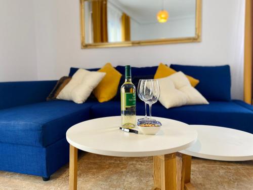 a blue couch with a bottle of wine and a glass at Apartment Costa Lunar in Cabo Roig in Playas de Orihuela