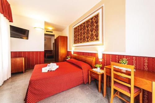 una camera d'albergo con letto rosso e tavolo di Hotel Napoleon a Cattolica