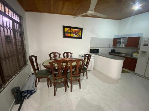 a dining room with a table and chairs in a kitchen at Acogedor y cómoda casa vacacional Condominios Flandes in Flandes