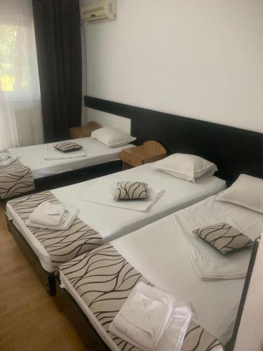 a group of three beds in a room at Motel Prietenia in Giurgiu