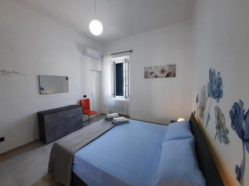 um quarto com uma cama azul e uma cadeira vermelha em Casa Vacanza Serena em Lecce