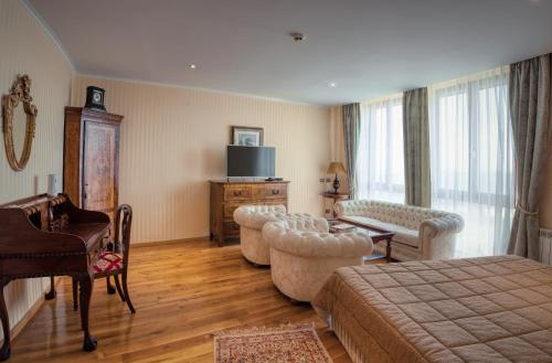 a hotel room with a bed and chairs and a television at Hotel Soli Invicto in Elenovo
