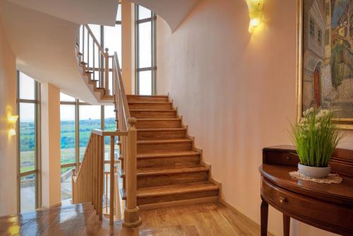 a staircase in a home with wooden floors and windows at Hotel Soli Invicto in Elenovo