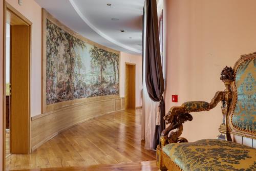a room with a painting on the wall and a chair at Hotel Soli Invicto in Elenovo