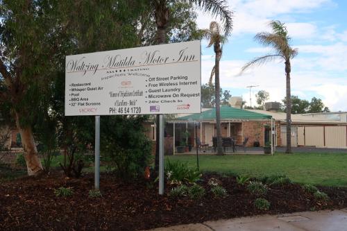 a sign in front of a park with a building at Charleville Waltzing Matilda Motor Inn in Charleville