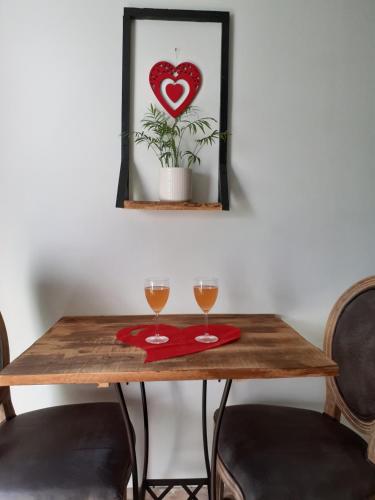 - une table avec deux verres de vin et une photo de cœur dans l'établissement La chambre des songes, à Saze