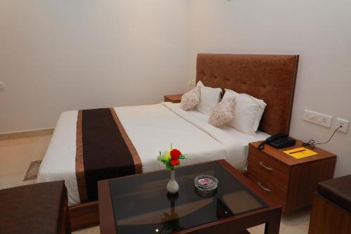 a hotel room with a large bed and a table at TM INN Hotel in Kanchipuram
