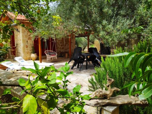 a patio with chairs and a table in a garden at Dreamy Stone House in Pesádha