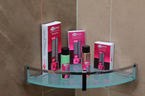 a shelf with four products on it in a bathroom at TM INN Hotel in Kanchipuram