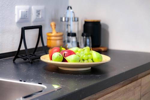 a bowl of apples and grapes on a kitchen counter at Dimora Bennardo in Palazzolo Acreide