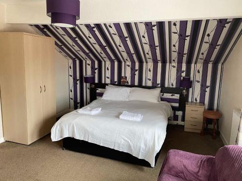 a bedroom with a bed with a black and white wall at Arncliffe Lodge Hotel in Blackpool