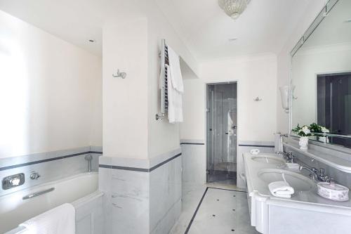 a white bathroom with a tub and a sink at Grand Hotel Timeo, A Belmond Hotel, Taormina in Taormina