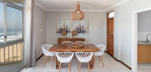 a dining room with a table and chairs at 806 Beachfront in Amanzimtoti