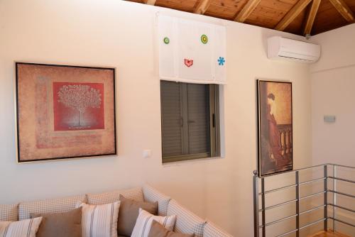 a living room with a couch and two pictures on the wall at Dio Guesthouses in Leonidion