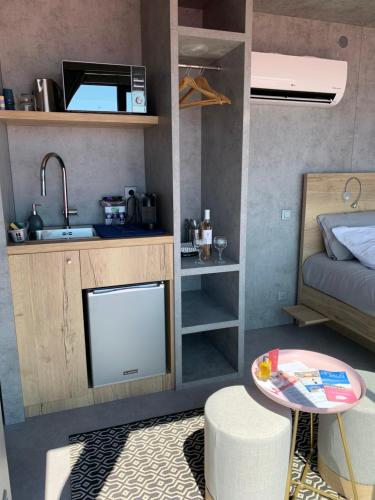 a small room with a kitchen and a bed and a table at Cabane SIRIUS Aigues-Mortes in Aigues-Mortes