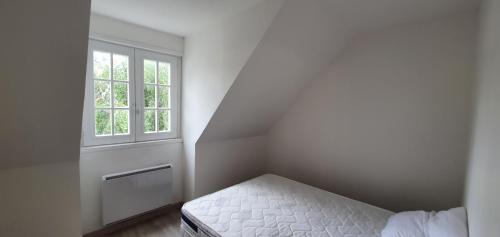 Habitación pequeña con cama y ventana en claire, en Camiers