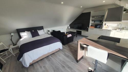 a bedroom with a large bed and a kitchen at The Loft , Portrush in Portrush