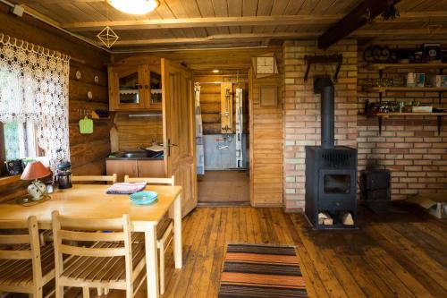 a dining room with a table and a wood stove at Auru Cīruļi in Auri